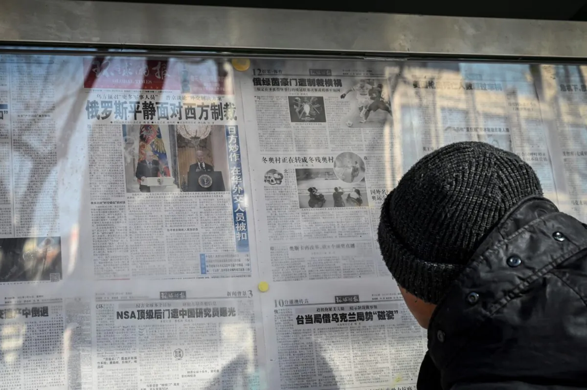 A man reads a Chinese state-run newspaper with coverage of the conflict between Russia and Ukraine, on a street in Beijing, China on Feb. 24, 2022. (Jade Gao/AFP via Getty Images)