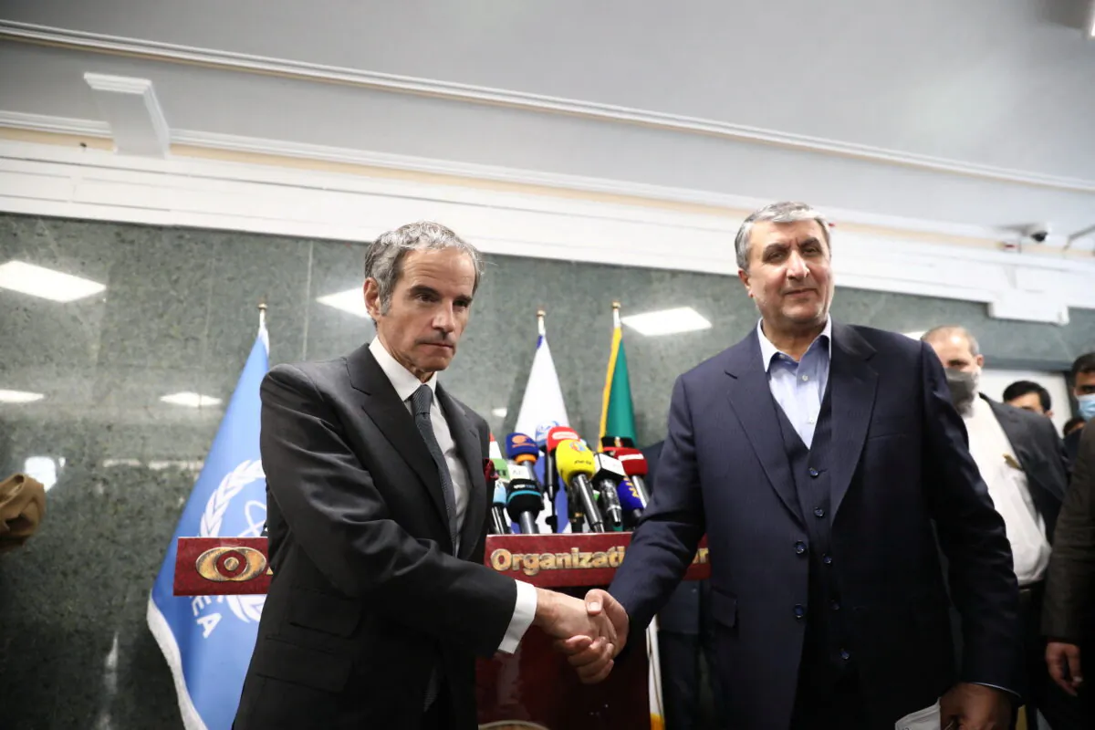 Head of Iran's Atomic Energy Organization Mohammad Eslami and International Atomic Energy Agency Director General Rafael Mariano Grossi shake hands after a news conference, in Tehran, Iran, on March 5, 2022. (West Asia News Agency via Reuters)