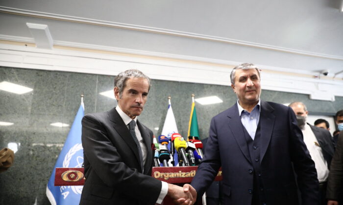 Head of Iran's Atomic Energy Organization Mohammad Eslami and International Atomic Energy Agency (IAEA) Director General Rafael Mariano Grossi shake hands after a news conference, in Tehran, Iran, on March 5, 2022. (West Asia News Agency via Reuters)