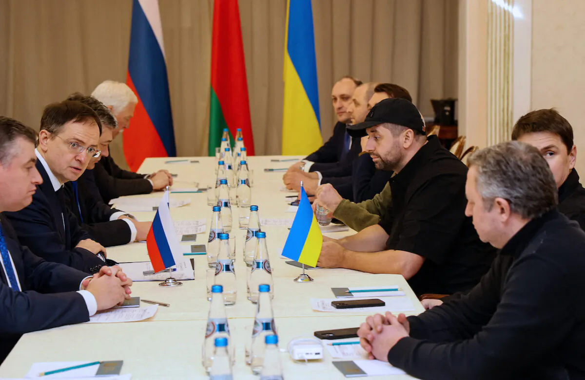 Denis Kireev, a member of the Ukrainian delegation (R, furthermost back of table) with other members of delegations from Ukraine and Russia, attend talks in Gomel region, Belarus, on Feb. 28, 2022. (Sergei Kholodilin/BELTA/AFP via Getty Images)