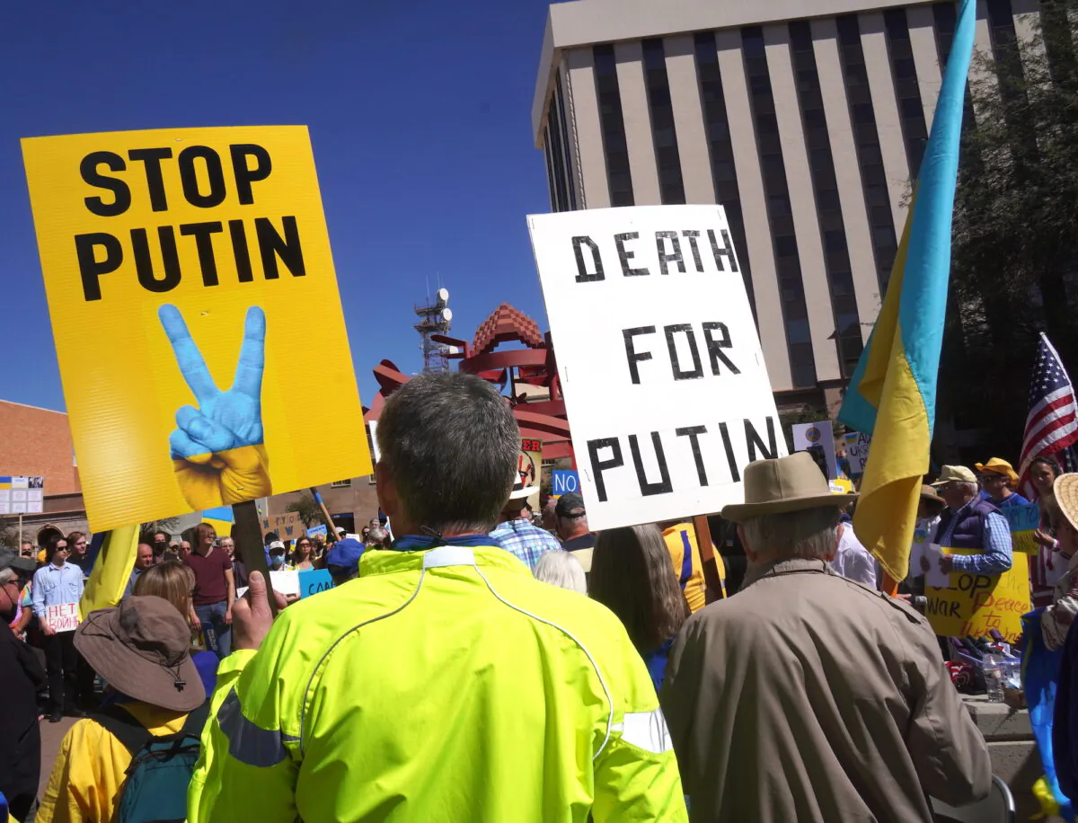 Protesters carry signs against the Russian invasion of Ukraine and Russian President Vladimir Putin during a rally in Tucson, Ariz., on March 6, 2022. (Allan Stein/The Epoch Times)