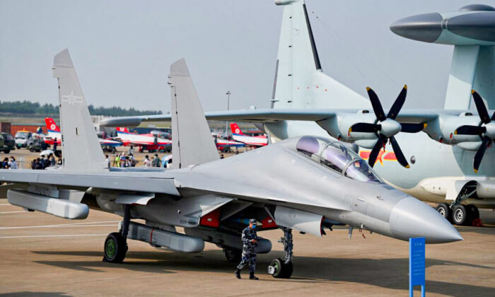 A military personnel walks past Shenyang Aircraft Corporation's J-16 multirole strike fighter for the People's Liberation Army Air Force at the 13th China International Aviation and Aerospace Exhibition in Zhuhai, southern China's Guangdong Province on Sept. 28, 2021. (NOEL CELIS/AFP via Getty Images)
