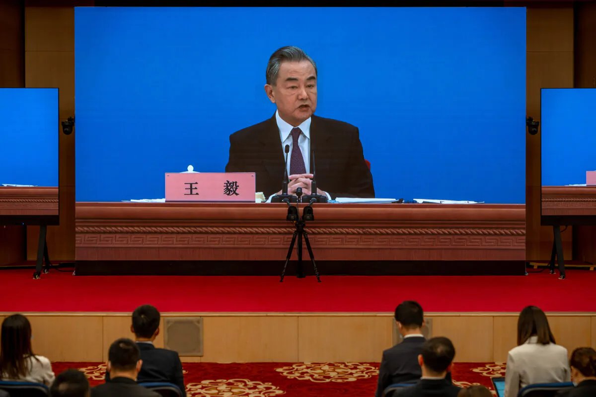 Chinese Foreign Minister Wang Yi is seen on large screens as he holds a press conference at the Media Center in Beijing, on March 7, 2022. (Andrea Verdelli/Getty Images)