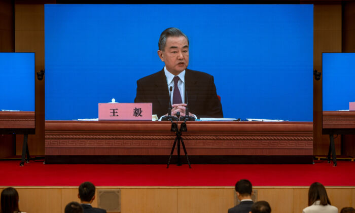 Chinese Foreign Minister Wang Yi is seen on large screens as he holds a press conference at the Media Center in Beijing, on March 7, 2022. (Andrea Verdelli/Getty Images)