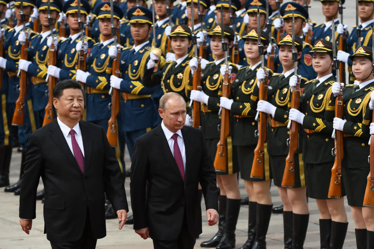 Russia's President Vladimir Putin reviews a military honor guard with Chinese leader Xi Jinping during a welcoming ceremony outside the Great Hall of the People in Beijing, China, on June 8, 2018. (Greg Baker/Pool/AFP via Getty Images)