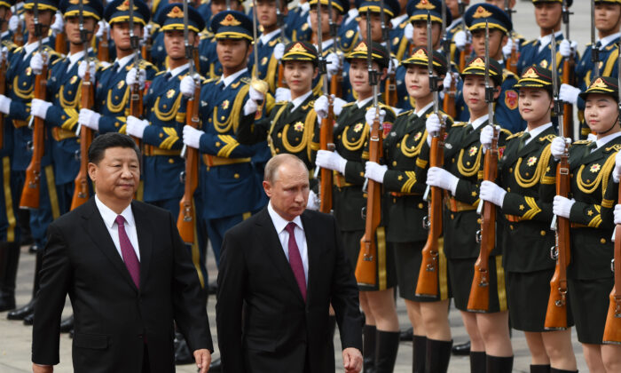 Russia's President Vladimir Putin (C) reviews a military honour guard with Chinese leader Xi Jinping (L) during a welcoming ceremony outside the Great Hall of the People in Beijing on June 8, 2018. (Greg Baker/POOL/AFP via Getty Images)