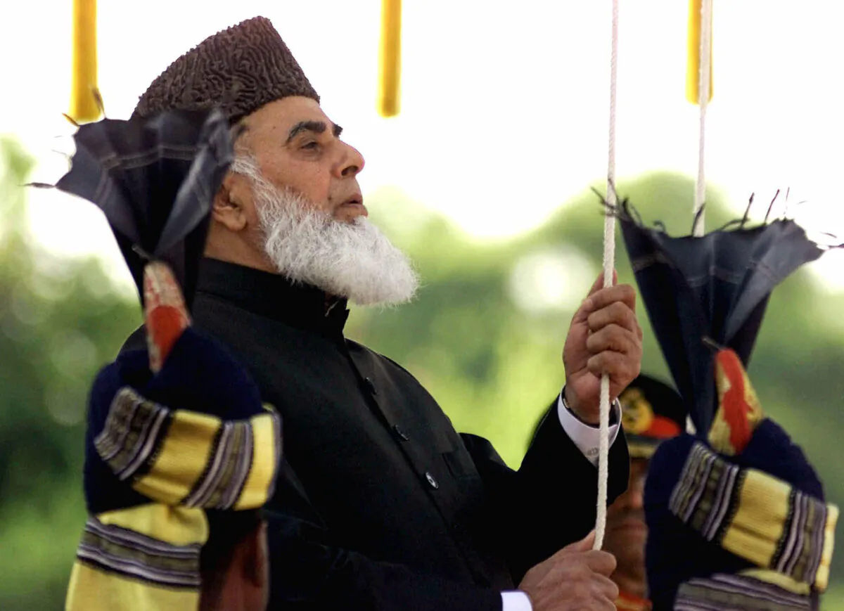 Former Pakistani President Rafiq Tarar hoists the Pakistani flag at the Presidential palace in Islamabad on Aug. 14, 2000. (B.K.Bangash/AP Photo)