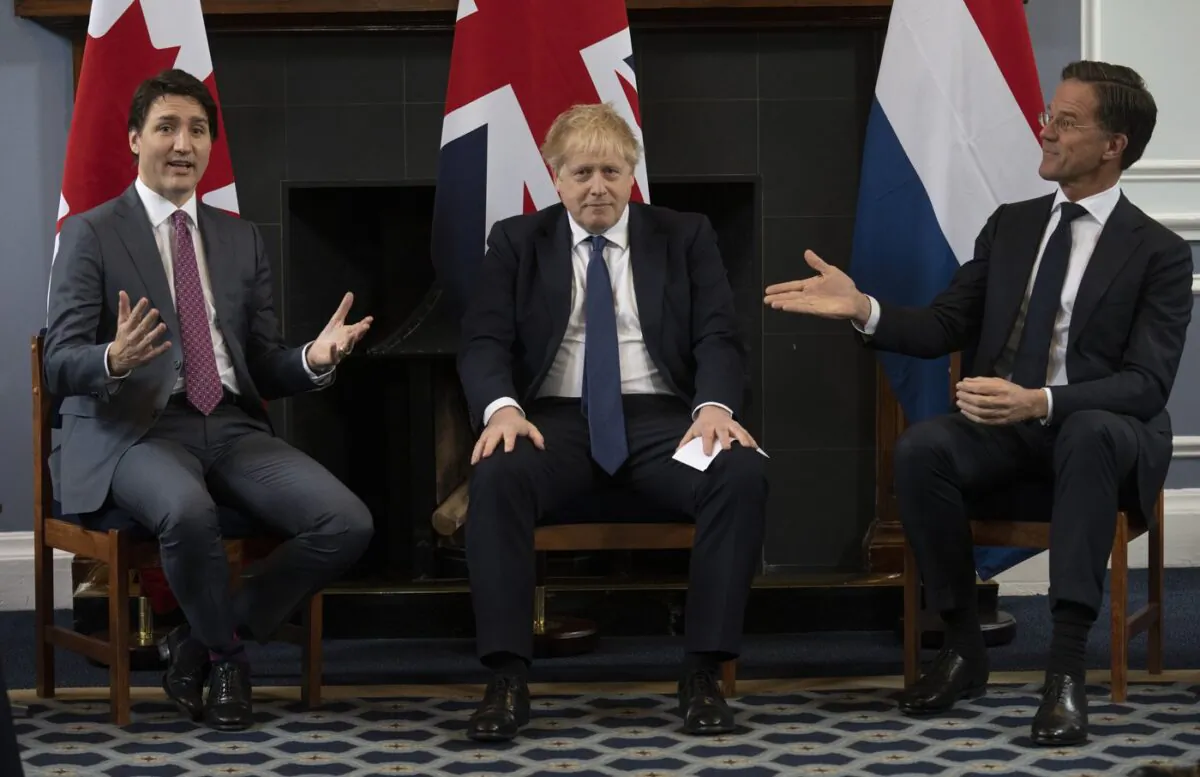 British Prime Minister Boris Johnson looks on as Prime Minister of the Netherlands Mark Rutte gestures to Canadian Prime Minister Justin Trudeau, March 7, 2022 at Royal Air Force station Northholt. (The Canadian Press/Adrian Wyld)
