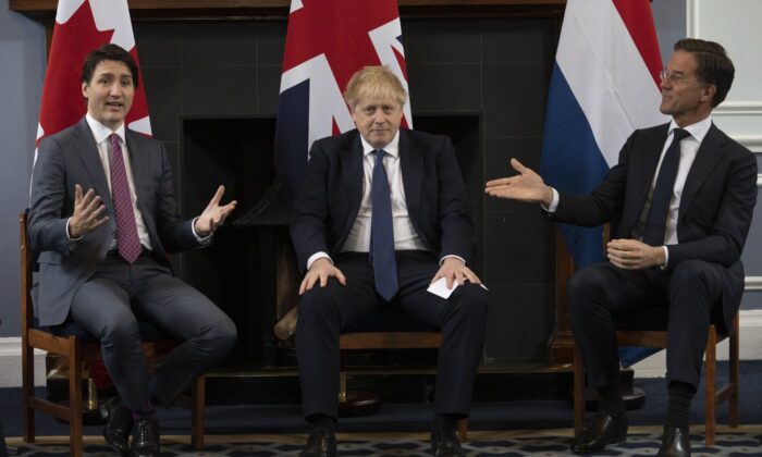 British Prime Minister Boris Johnson looks on as Prime Minister of the Netherlands Mark Rutte gestures to Canadian Prime Minister Justin Trudeau, March 7, 2022 at Royal Air Force station Northholt. (The Canadian Press/Adrian Wyld)