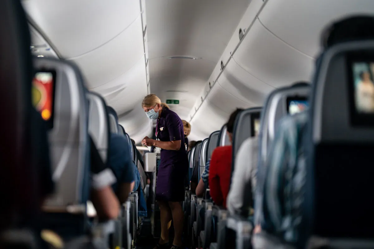 Flight attendants hand out refreshments to a packed Delta Air Lines flight on May 21, 2021. (Kent Nishimura/Los Angeles Times/TNS)