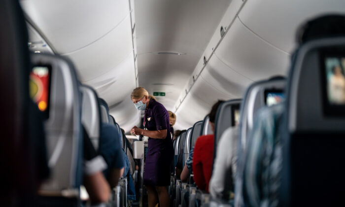 Flight attendants hand out refreshments to a packed Delta Air Lines flight on May 21, 2021. (Kent Nishimura/Los Angeles Times/TNS)