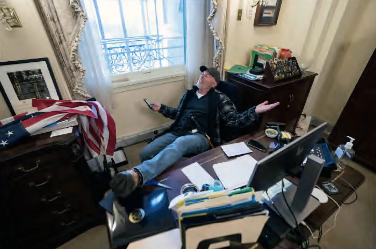 Richard 'Bigo' Barnett poses for photos in the office of House Speaker Nancy Pelosi on Jan. 6, 2021. He would have received roughly six to seven years in prison under a plea offer that his attorney called "ridiculous." (U.S. Department of Justice/Screenshot via The Epoch Times)