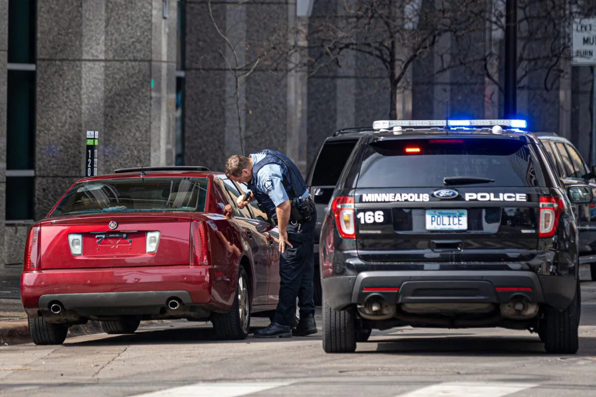 A police officer checks a suspicious car without a plate parked near the Hennepin County Government Center in Minneapolis on March 9, 2021. (Photo by Kerem Yucel/AFP via Getty Images)