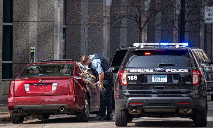 A police officer checks a suspicious car without a plate parked near the Hennepin County Government Center in Minneapolis on March 9, 2021. (Photo by Kerem Yucel/AFP via Getty Images)