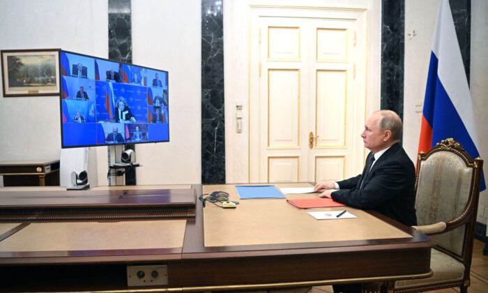 Russian President Vladimir Putin chairs a meeting with members of the Security Council via teleconference call at the Novo-Ogaryovo state residence outside Moscow, on Feb. 18, 2022. (Mikhail Klimentyev / Sputnik/AFP via Getty Images)