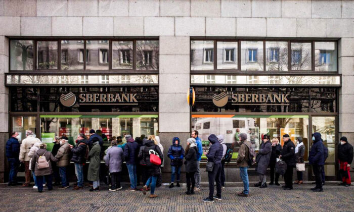 People queue outside a branch of Russian state-owned bank Sberbank to withdraw their savings and close their accounts in Prague on Feb. 25, 2022, before Sberbank closed all its branches in the Czech Republic later in the day. (Michal Cizek/AFP via Getty Images)