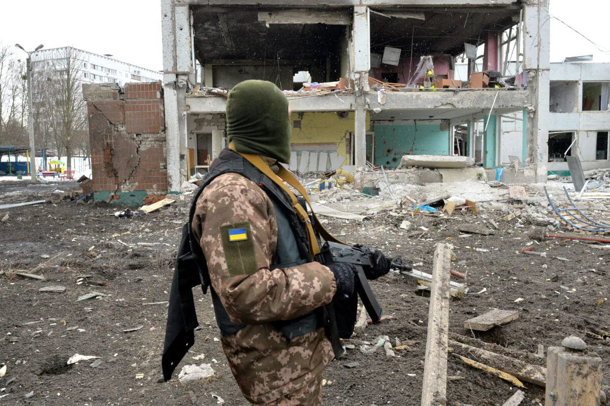 A member of the Ukrainian Territorial Defence Forces looks at destructions following a shelling in Ukraine's second-biggest city of Kharkiv on March 8, 2022. (Sergey Bobok/AFP via Getty Images)