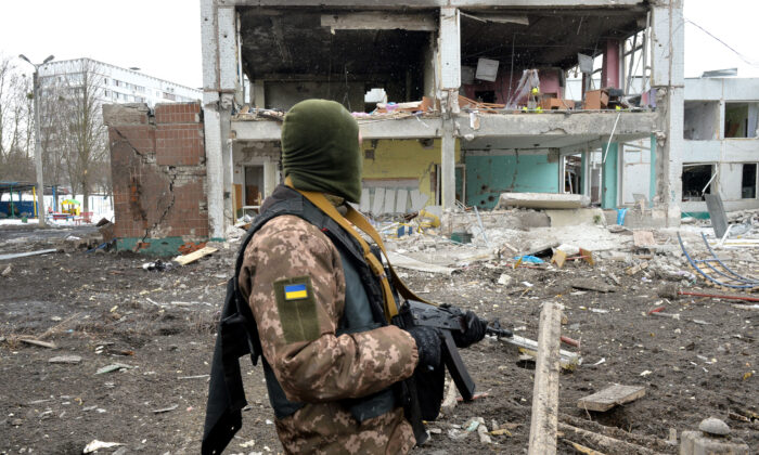 A member of the Ukrainian Territorial Defence Forces looks at destructions following a shelling in Ukraine's second-biggest city of Kharkiv on March 8, 2022. (Sergey Bobok/AFP via Getty Images)