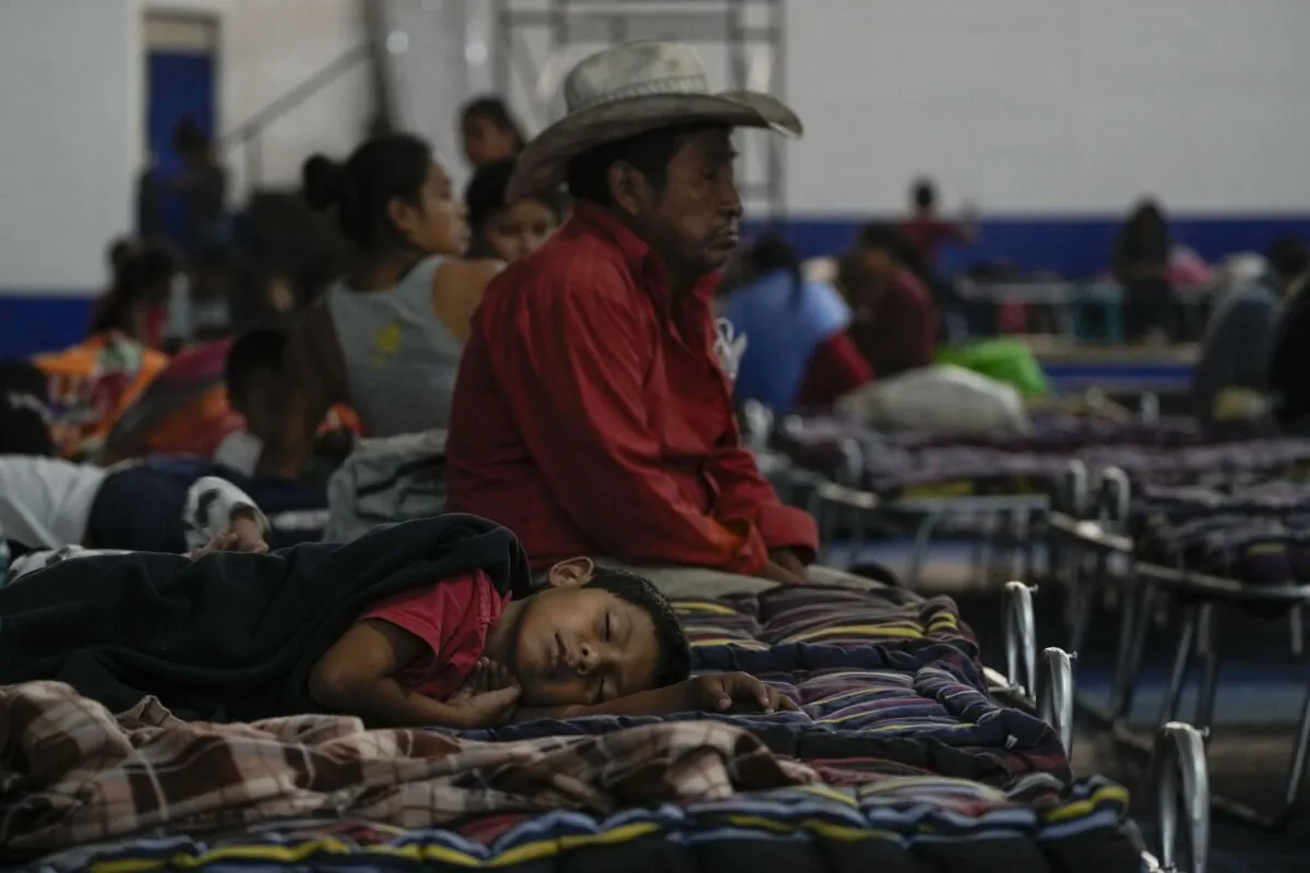 People gather inside a gym set up as a shelter for those evacuating from the slopes of the Fuego volcano in Santa Lucia Cotzumalguapa, Guatemala on March 8, 2022. (Moises Castillo/AP Photo)