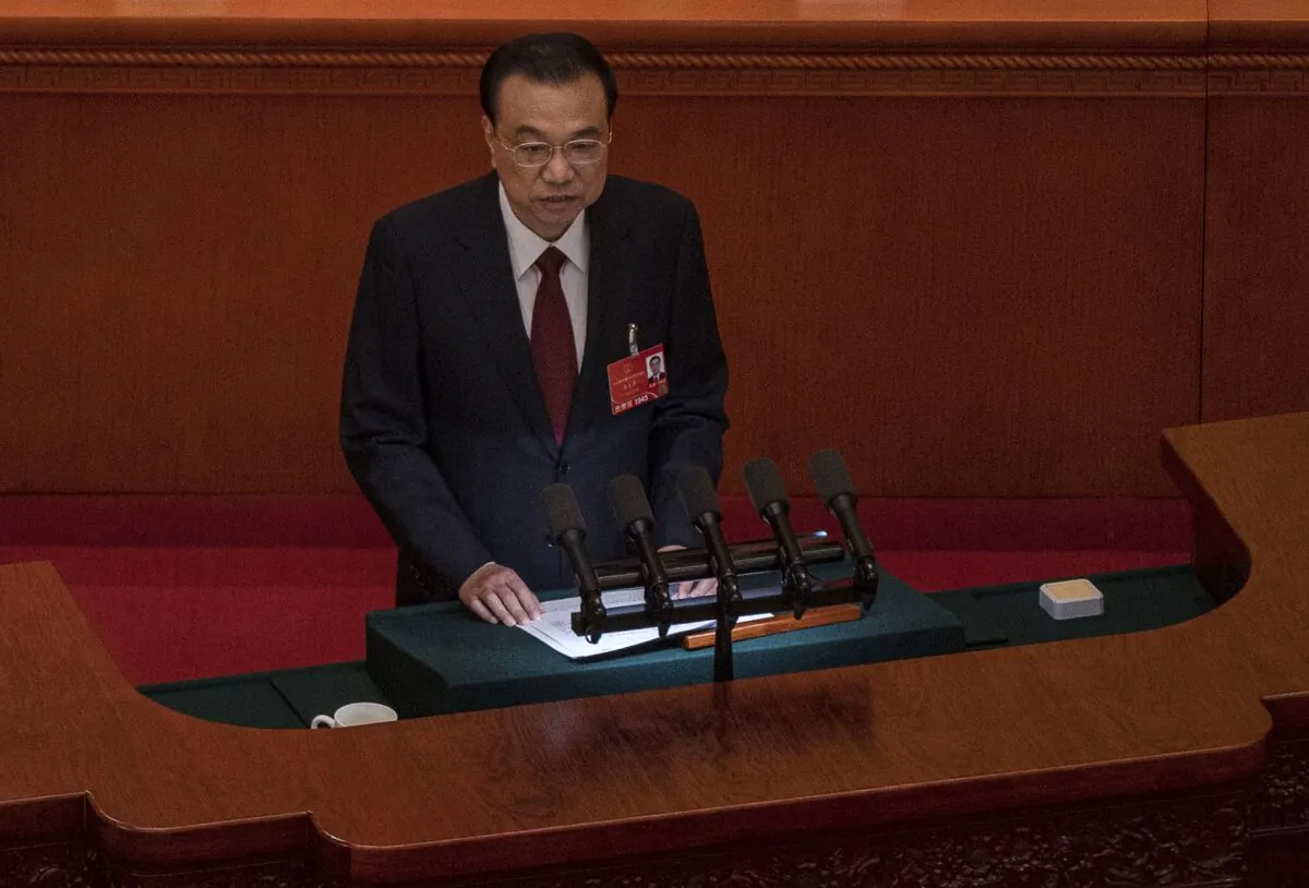Chinese Premier Li Keqiang speaks from the podium at the opening session of the National Peoples Congress at the Great Hall of the People in Beijing, China, on March 5, 2022. (Kevin Frayer/Getty Images)