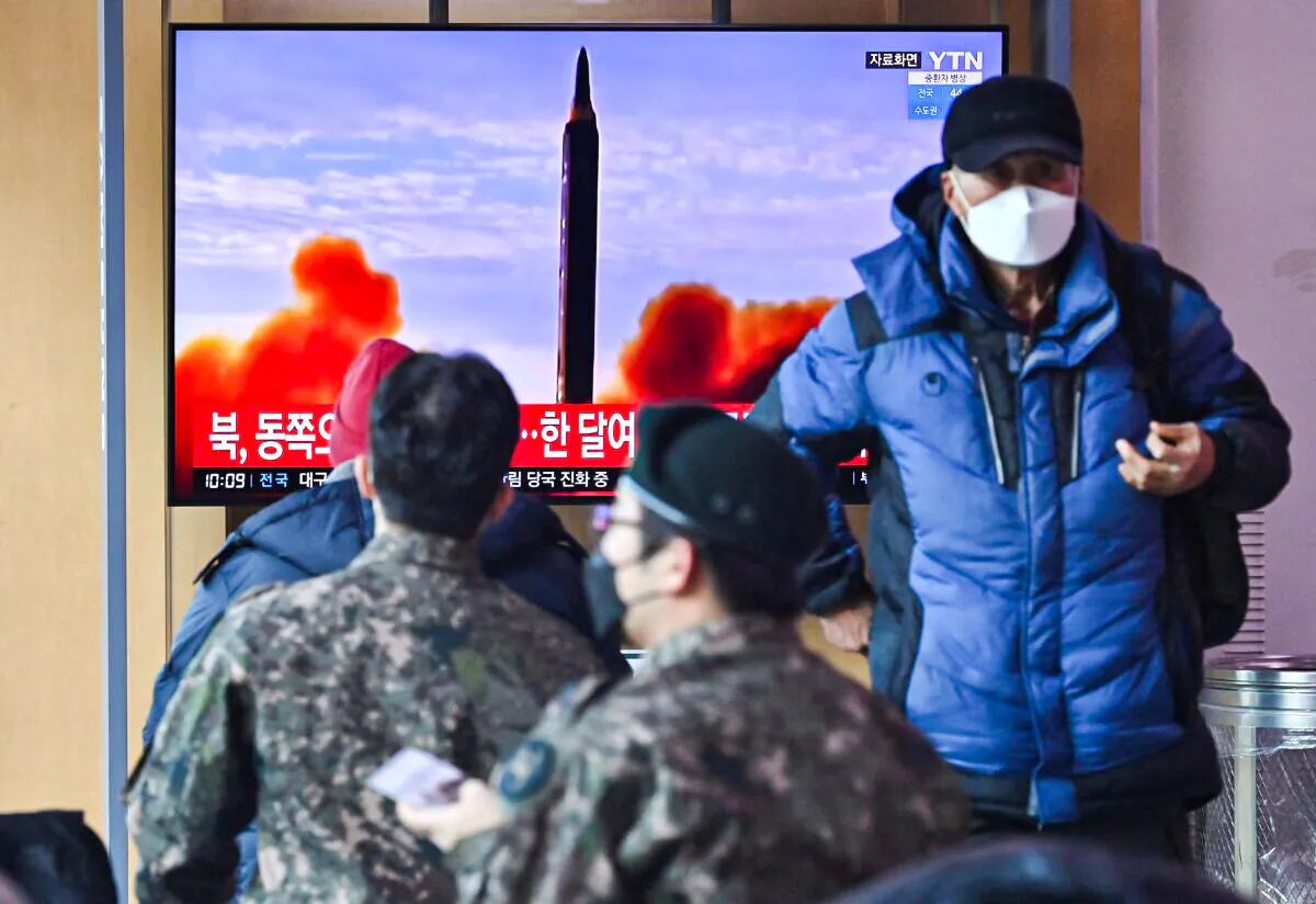 People watch a television screen showing a news broadcast with file footage of a North Korean missile test, at a railway station in Seoul, South Korea, on Feb. 27, 2022. (Jung Yeon-je/AFP via Getty Images)
