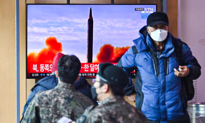 People watch a television screen showing a news broadcast with file footage of a North Korean missile test, at a railway station in Seoul, South Korea, on Feb. 27, 2022. (Jung Yeon-je/AFP via Getty Images)