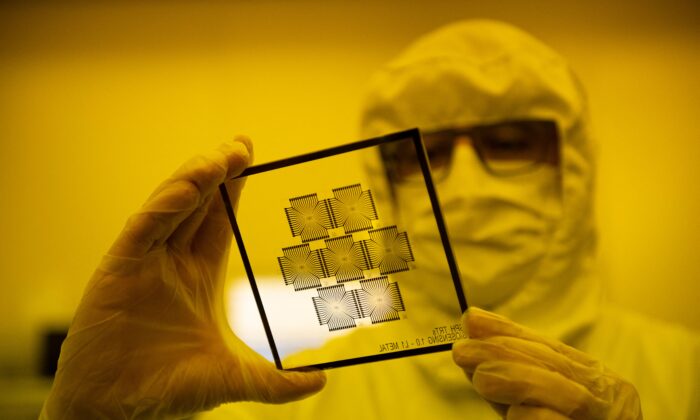 An employee works in the chip manufacturing process at a clean room of the Barcelona Institute for Microelectronics (IMB-CNM) in Bellaterra, near Barcelona, on March 3, 2022. (Josep Lago/AFP via Getty Images)