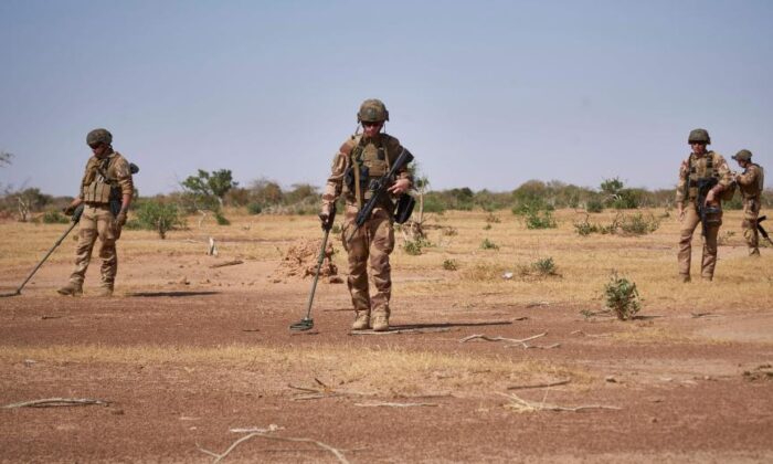 Soldiers from the French army search for the presence of Improvised Explosive Devices during the Burkhane Operation in northern Burkina Faso on Nov. 12, 2019. (Michelle Cattani/ AFP/Getty Image) 
