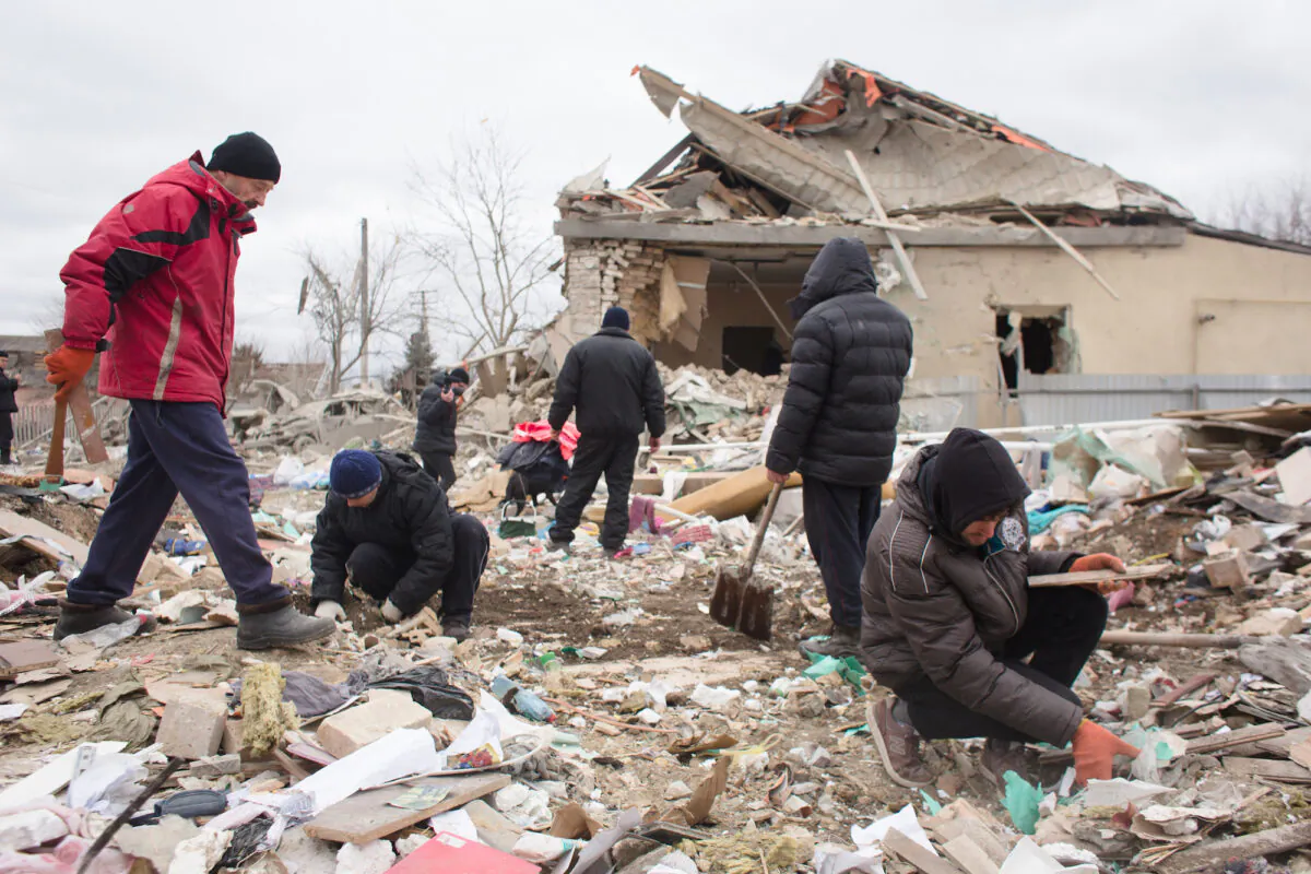 Neighbors and relatives help remove the rubble of a house destroyed with shelling in Markhalivka, Ukraine, on March 5, 2022. (Anastasia Vlasova/Getty Images)