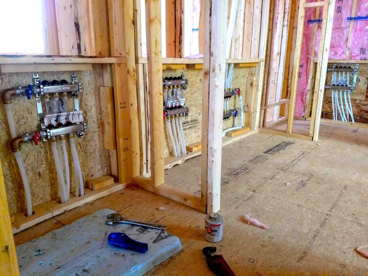 Attached to the wall are radiant heating distribution manifolds. Hot water enters the manifold and is sent through the smaller tubing to heat the floors in this house. It then returns to the boiler to get reheated. (Tim Carter/TNS)