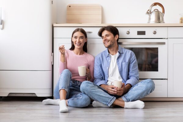 couple sitting in kitchen drinking coffee