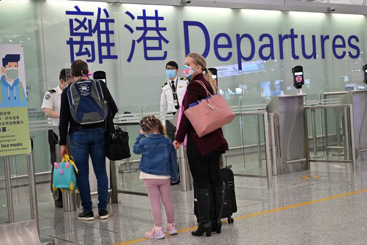 A family departs Hong Kong's Chek Lap Kok international airport on March 6, 2022 as travel restrictions hit Hong Kong's white collar foreign workers hard. (Peter Parks/AFP via Getty Images)