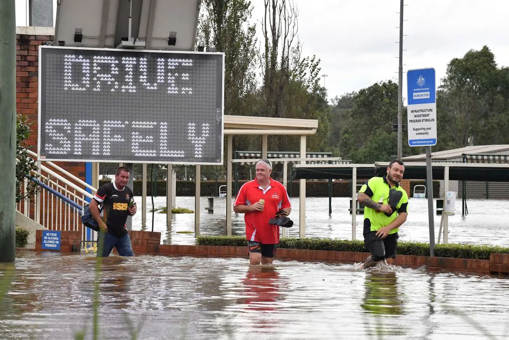 Residents wade through the rising floodwaters in southwestern Camden suburb of Sydney, Australia on March 8, 2022. (Muhammad Farooq/AFP via Getty Images)
