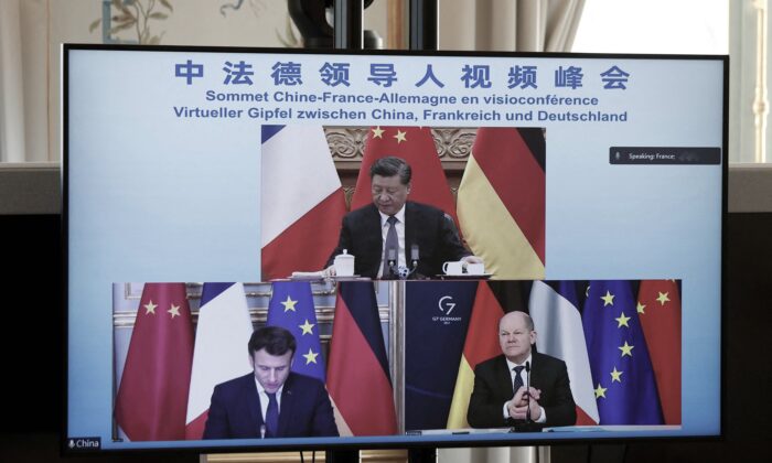 A video screen displays French President Emmanuel Macron (bottom left), German Chancellor Olaf Scholz (bottom right), and Chinese leader Xi Jinping (top) attending a video conference to discuss the Ukraine crisis at the Elysee Palace in Paris, France, on March 8, 2022. (Benoit Tessier/AFP via Getty Images)
