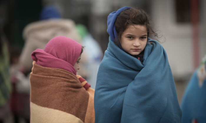 Refugee children fleeing Ukraine are given blankets by Slovakian rescue workers to keep warm at the Velke Slemence border crossing in Velke Slemence, Slovakia, on March 9, 2022. (Christopher Furlong/Getty Images)