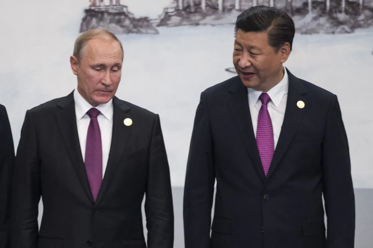 Chinese President Xi Jinping (R) and Russian President Vladimir Putin pose for a family photo during the BRICS Summit in Xiamen, Fujian Province on Sept. 4, 2017.
(Fred Dufour/AFP via Getty Images)