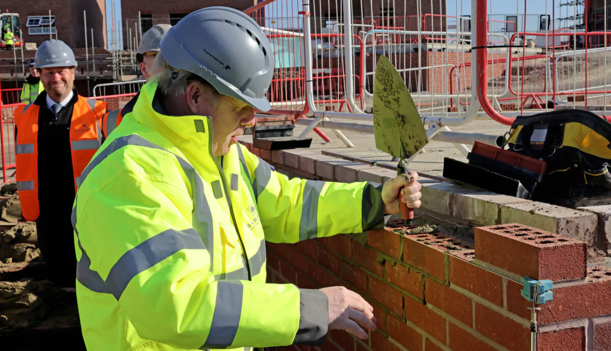 British Prime Minister Boris Johnson tries his hand at bricklaying in Oldbury, UK, on April 19, 2021. (Jonathan Buckmaster - WPA Pool/Getty Images)