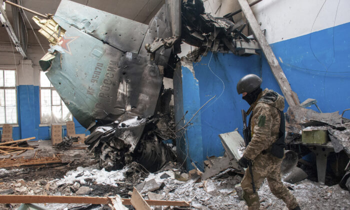 A Ukrainian serviceman walks past the vertical tail fin of a Russian Su-34 bomber lying in a damaged building in Kharkiv, Ukraine, on March 8, 2022. (Andrew Marienko/AP Photo)