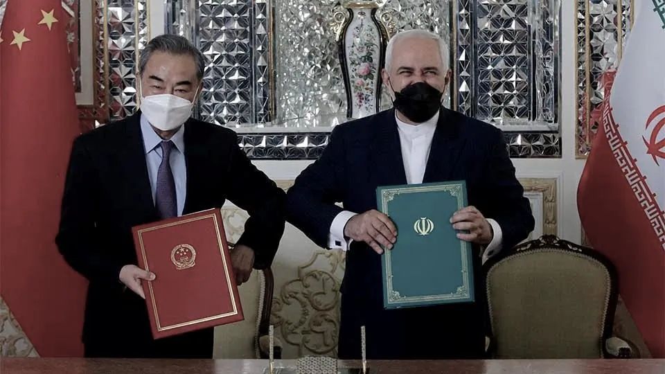 Then-Iranian Foreign Minister Mohammad Javad Zarif (R) and his Chinese counterpart Wang Yi, pose for a picture after signing an agreement in Tehran, Iran, on March 27, 2021. (AFP via Getty Images)
