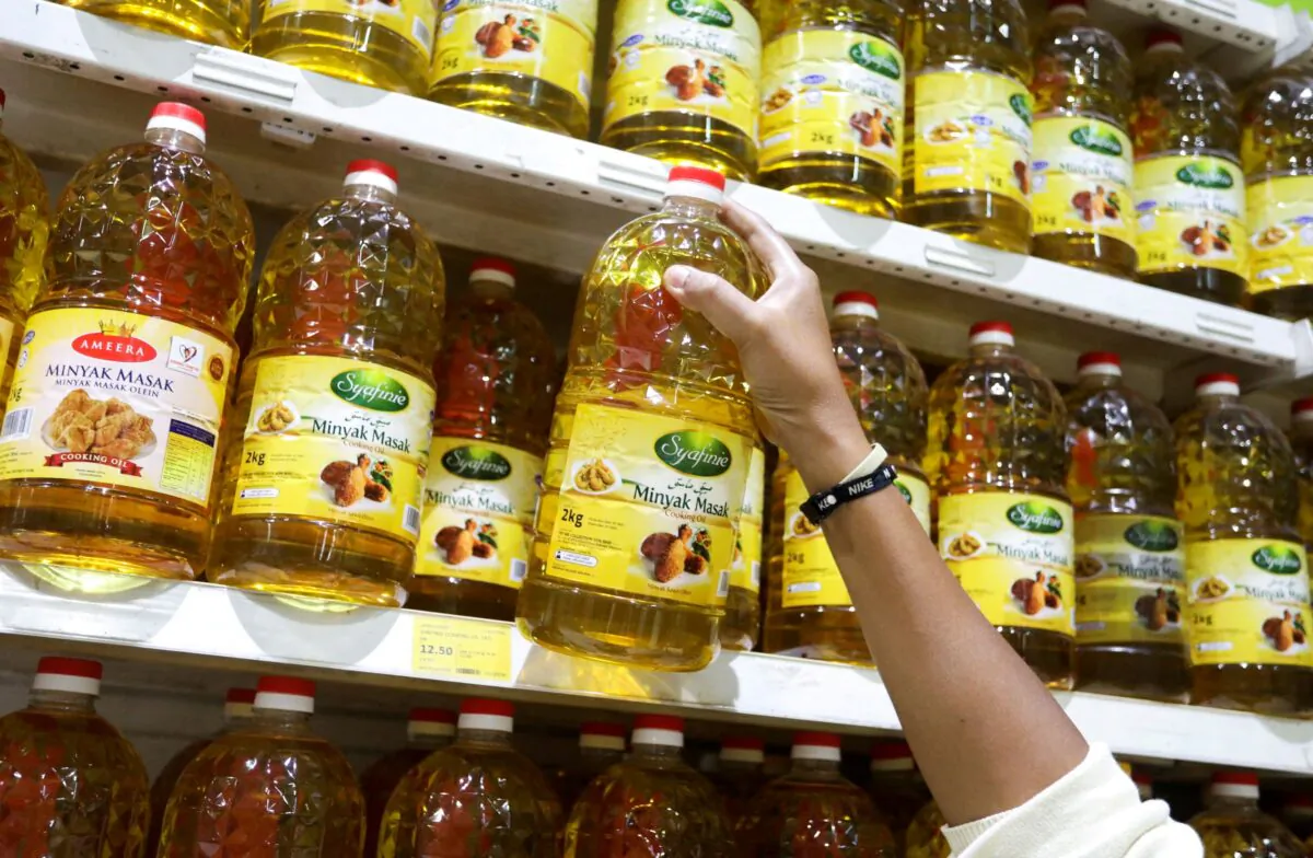 A person holds bottles of cooking oil made from oil palms at a supermarket in Subang Jaya, Malaysia, on March 8, 2022. (Hasnoor Hussain/Reuters)