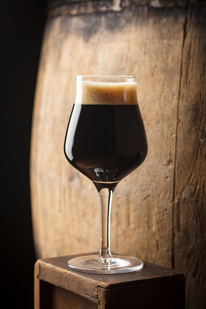 Glass,Of,Dark,Stout,Beer,Standing,Near,An,Old,Wooden