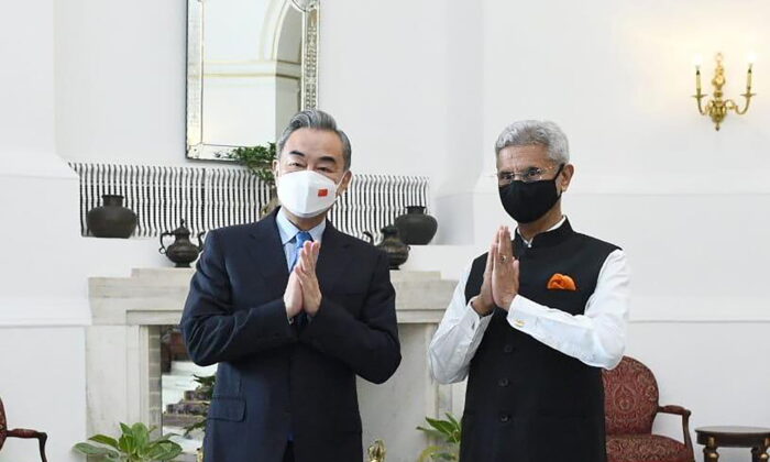 Chinese Foreign Minister Wang Yi and his counterpart S. Jaishankar greet the media before their meeting in New Delhi, India, on March 25, 2022. (Indian Foreign Minister S. Jaishankar's Twitter handle via AP)