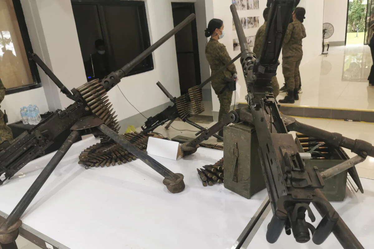 Soldiers stand beside some of the 45 pieces of firearms seized by army troops from Muslim insurgents aligned with the ISIS terrorist group in Marawi City, southern Philippines, on March 3, 2022. (Froilan Gallardo/AP Photo)