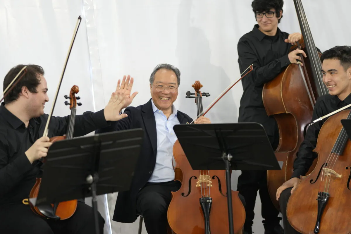 World renown U.S. cellist Yo-Yo Ma high fives after a performance at the Music School of the National Conservatory in Lisbon, Portugal, on March 29, 2022. (Armando Franca/AP Photo)
