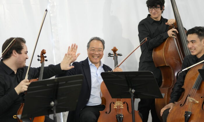 World renown U.S. cellist Yo-Yo Ma high fives after a performance at the Music School of the National Conservatory in Lisbon, Portugal, on March 29, 2022. (Armando Franca/AP Photo)