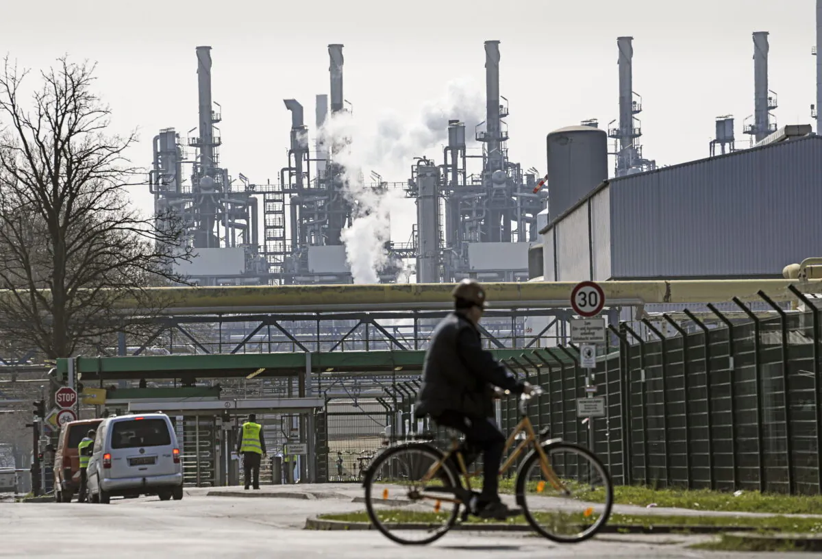 A worker rides his bicycle to the BP oil refinery Ruhr Oil in Gelsenkirchen, Germany, on March 28, 2022. (Martin Meissner/AP Photo)