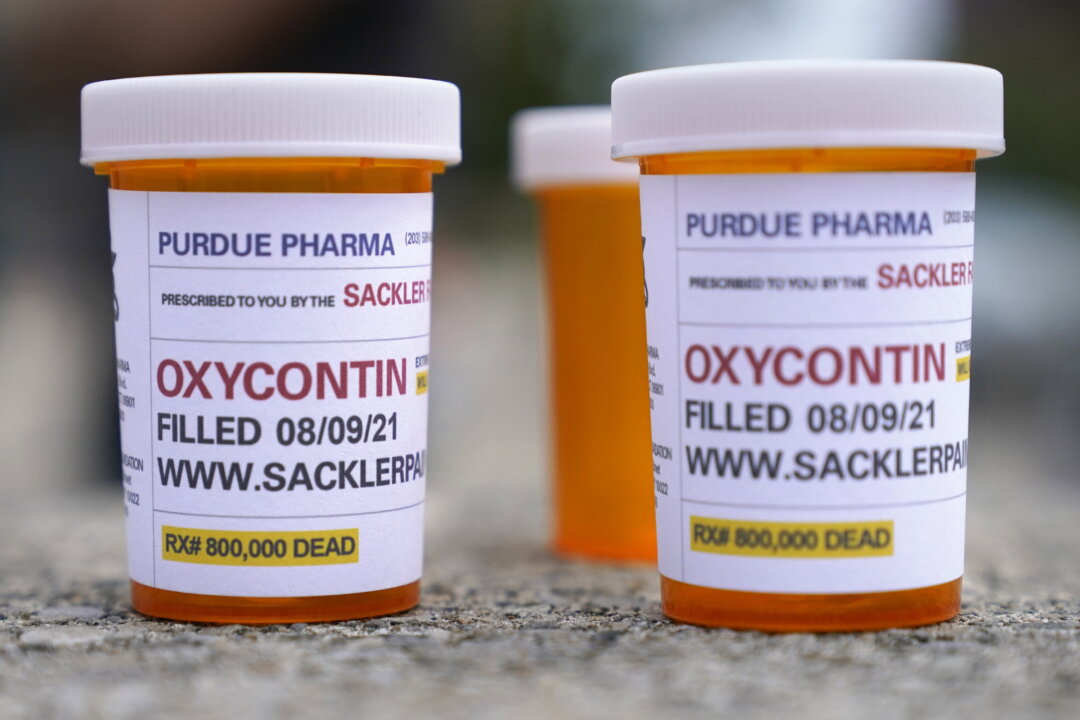 Fake pill bottles with messages about OxyContin maker Purdue Pharma are displayed during a protest outside the courthouse where the bankruptcy of the company is taking place in White Plains, N.Y., on Aug. 9, 2021.  (Seth Wenig/AP Photo)