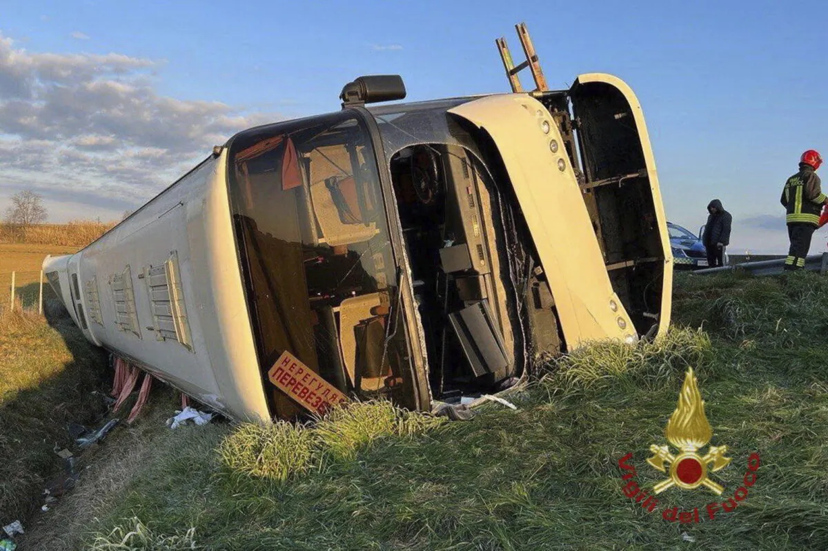 A bus carrying about 50 refugees from Ukraine lies on its side after overturning near Forli, Italy, on March 13, 2022. (Vigili del Fuoco via AP)