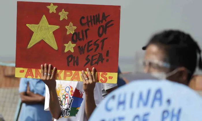 An activist holds a sign against a Chinese Coast Guard law during a rally in Manila, Philippines, on Feb. 24, 2021. (Aaron Favila/AP Photo)
