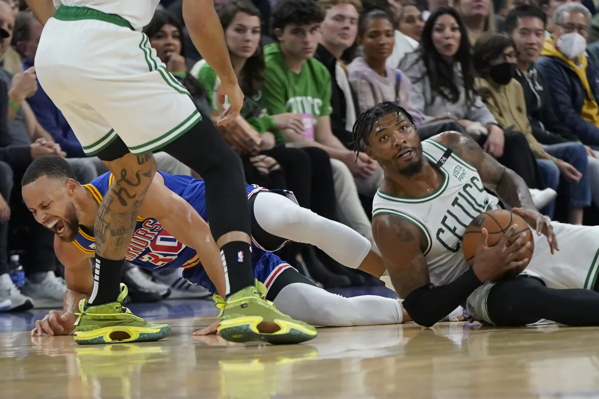 Golden State Warriors guard Stephen Curry (L) reacts after going for a loose ball next to Boston Celtics guard Marcus Smart during the first half of an NBA basketball game in San Francisco on March 16, 2022. (Jeff Chiu/AP Photo)